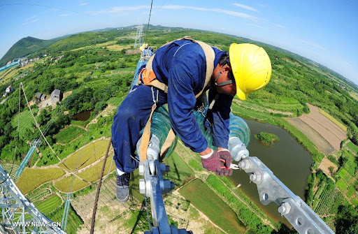 Technician working on an electricity transmission tower.